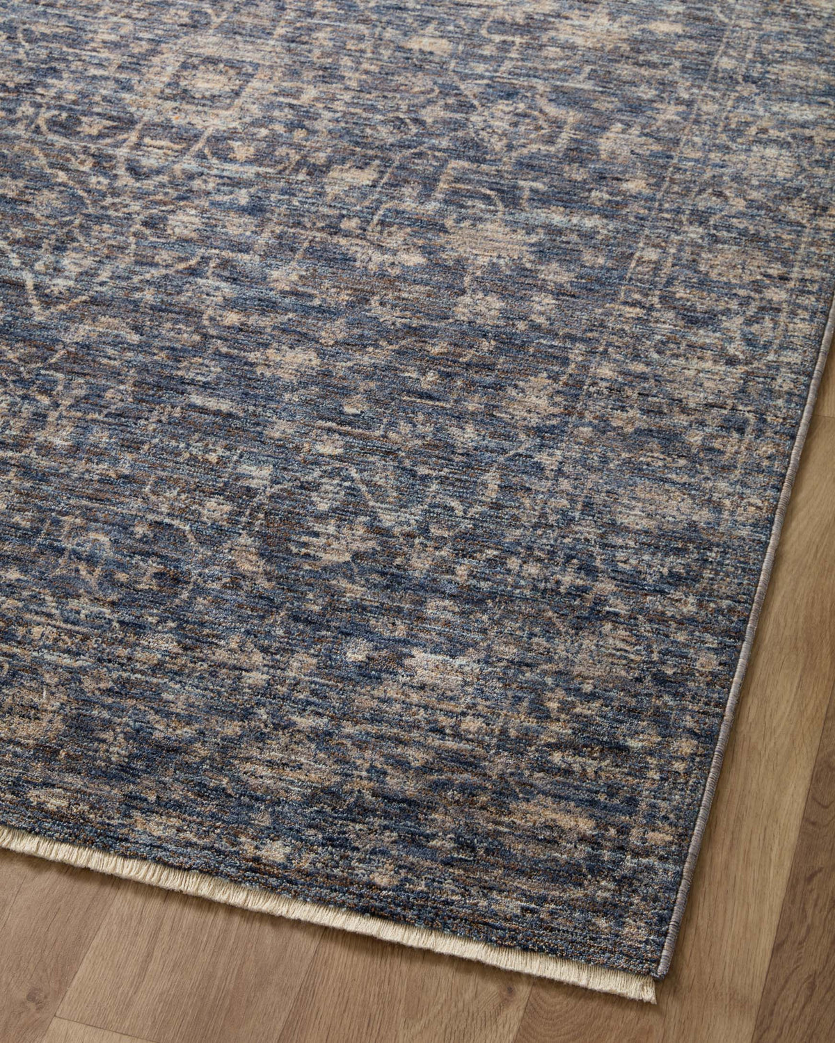 Blue and beige traditional area rug with distressed motifs and short dense pile