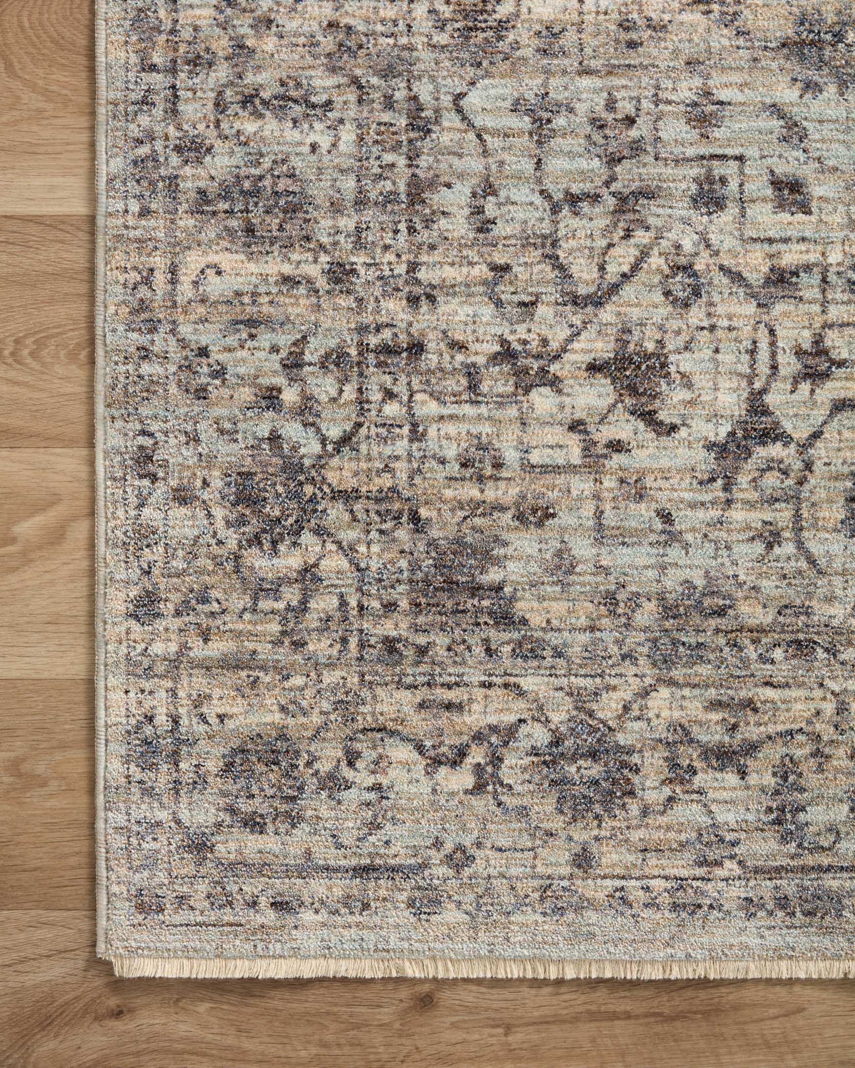 Corner of mist and charcoal traditional runner rug with distressed geometric motif and fringe detail