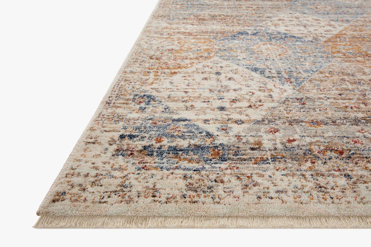 Traditional accent rug, ivory base with blue and rust geometric pattern, fringed edge.