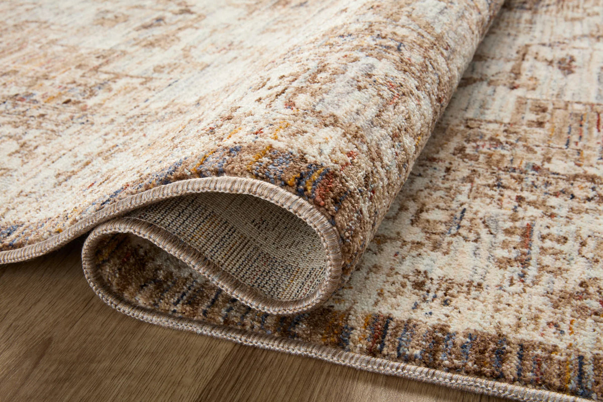 Close-up of beige and mocha rug pile with distressed pattern and stitched edge