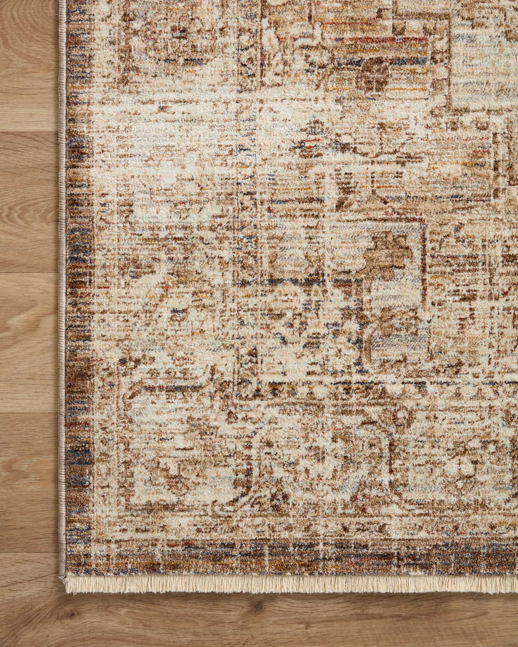 Corner view of beige traditional area rug with mocha-brown distressed pattern and flat weave.