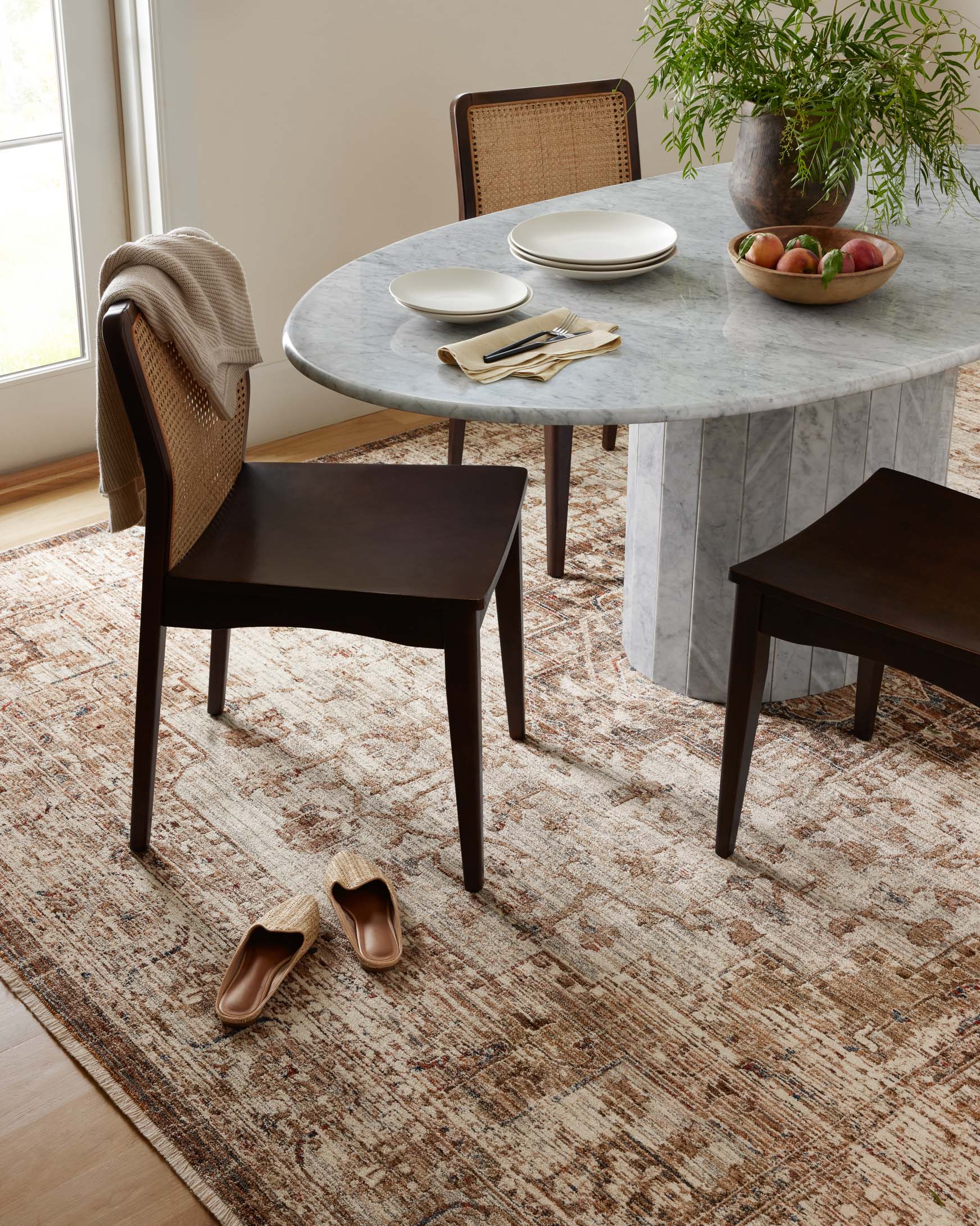 Mocha and tan traditional accent rug under round dining table