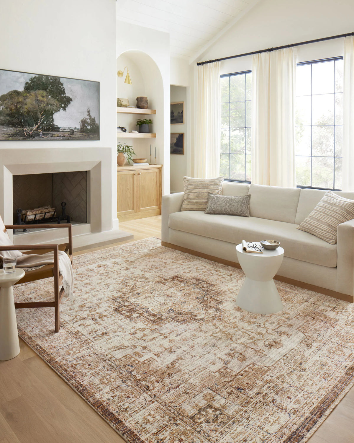 Traditional beige and mocha rug with distressed ornate pattern on hardwood floor.