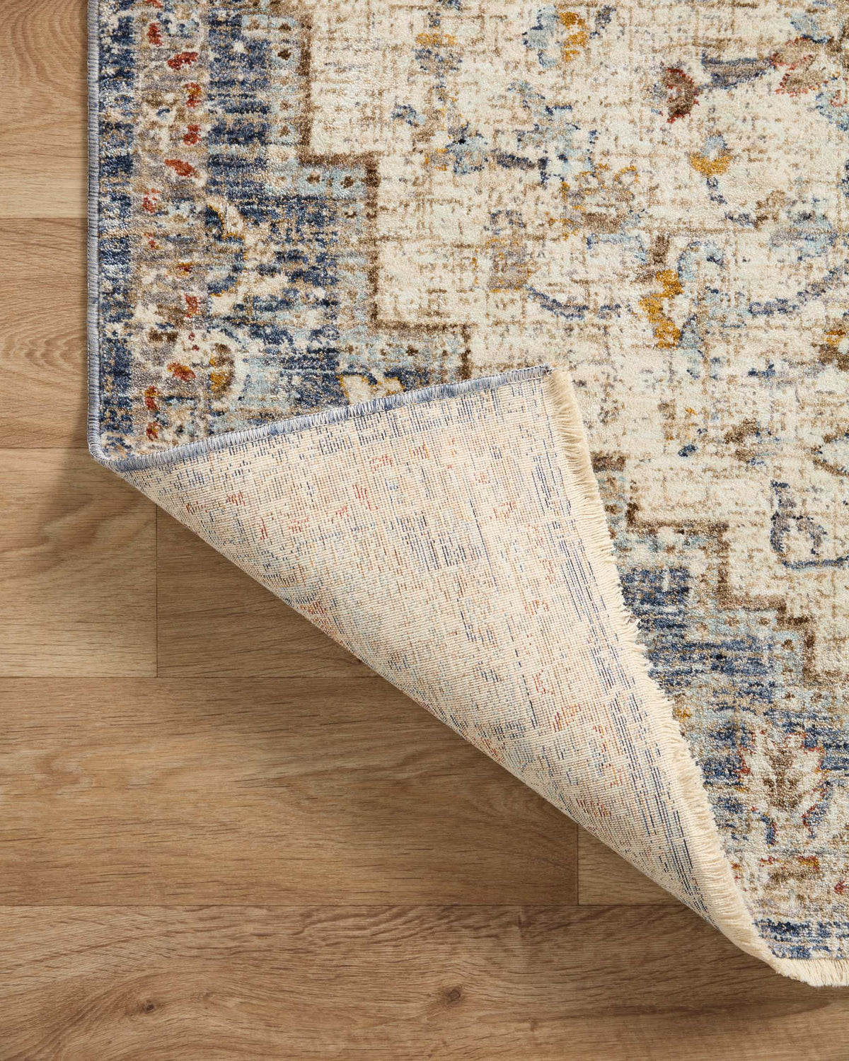 Traditional round accent rug showing underside weave in light beige with blue edge binding