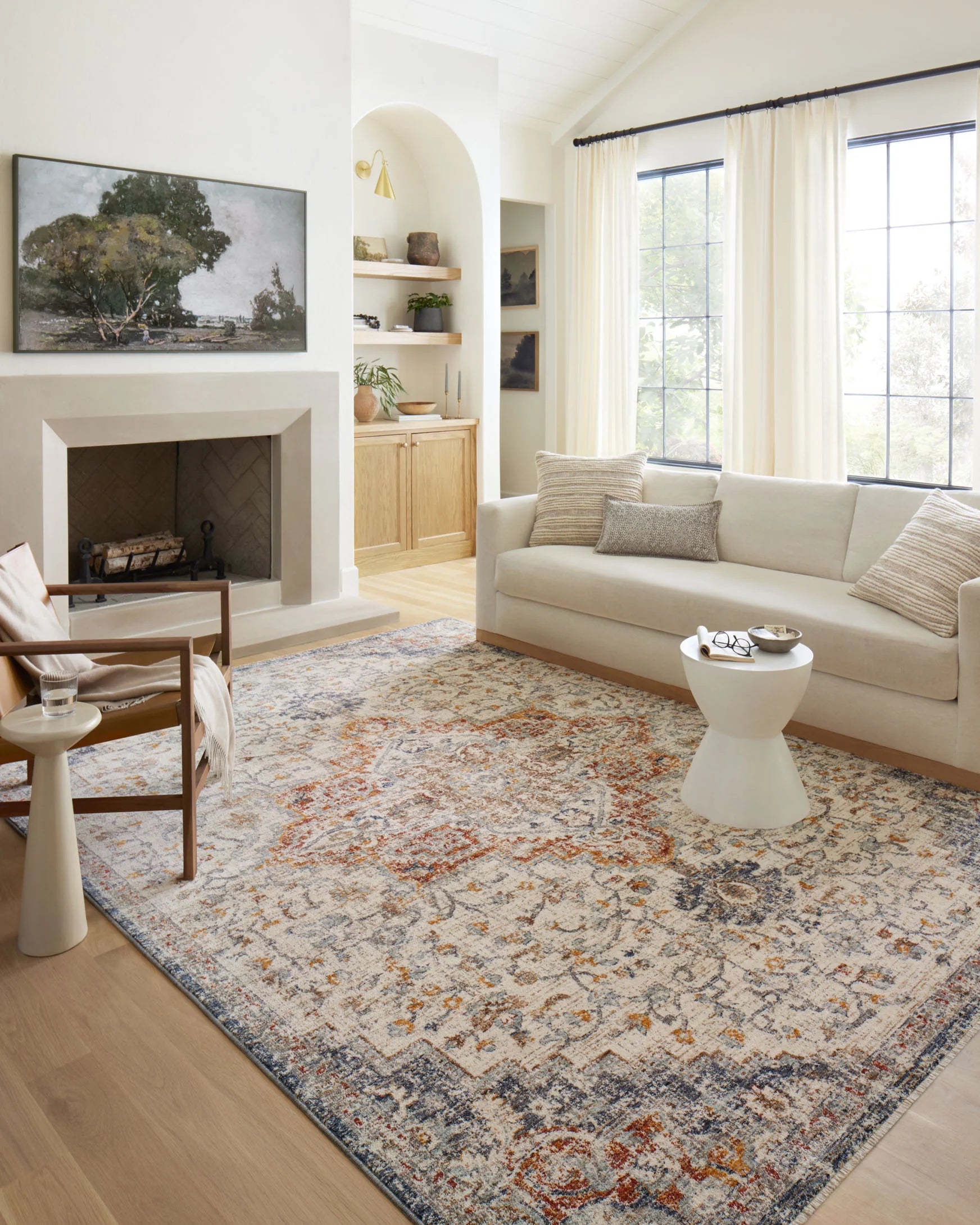 Traditional ivory area rug with blue and orange ornate pattern in a living room
