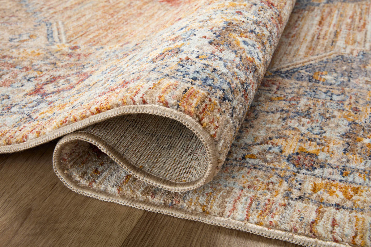 Rolled corner of a traditional area rug showing multicolor weave and fringed trim