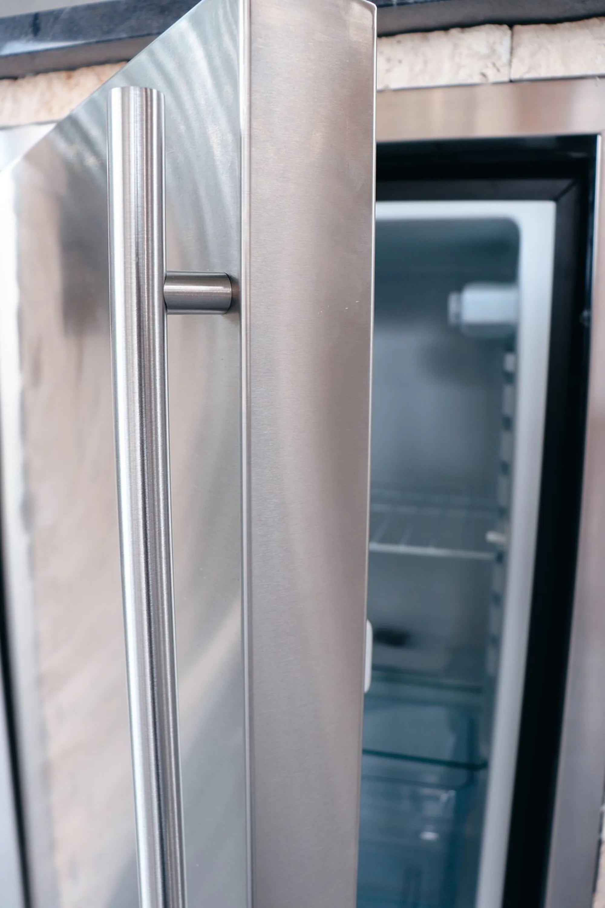 Stainless steel refrigerator door liner close-up of vertical handle and edge