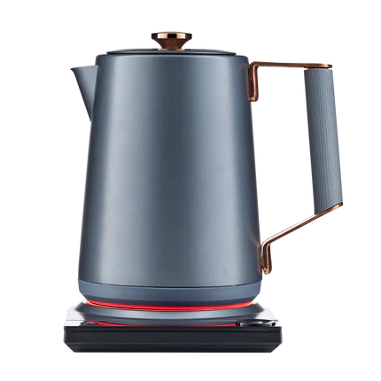 Midnight blue electric kettle on base with copper accents and heating ring