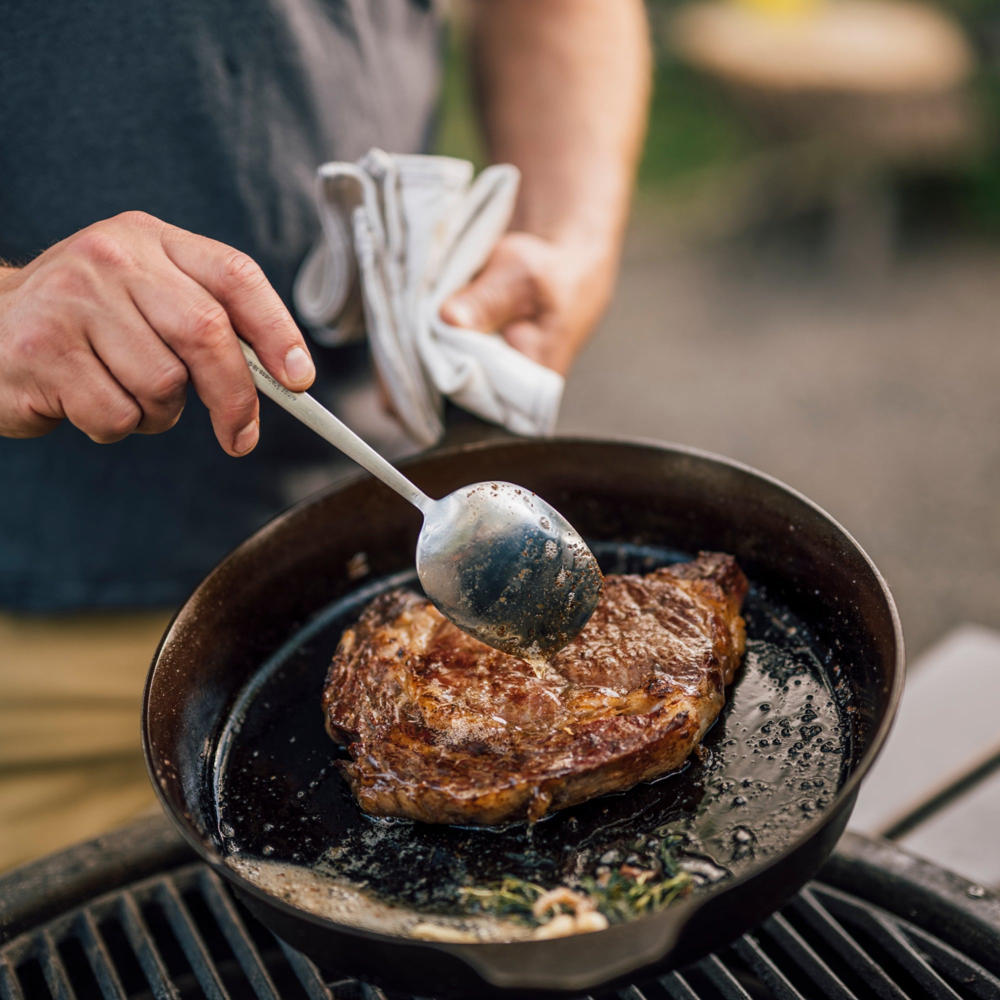 Cast-iron skillet with browned steak and a spatula in a pan