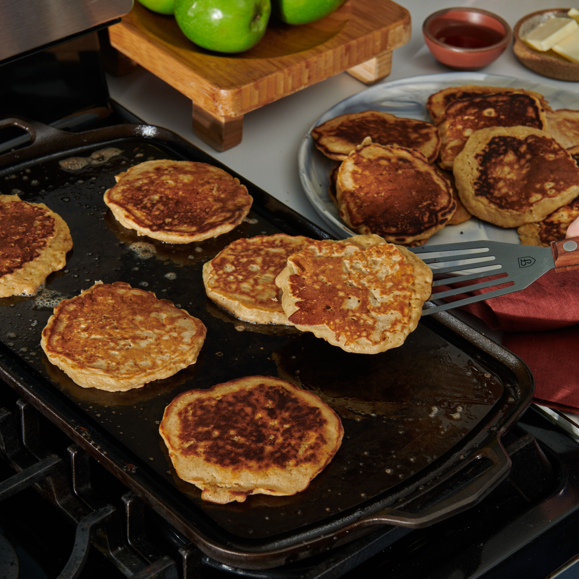 Cast iron griddle cooking pancakes on a grill, dark griddle surface