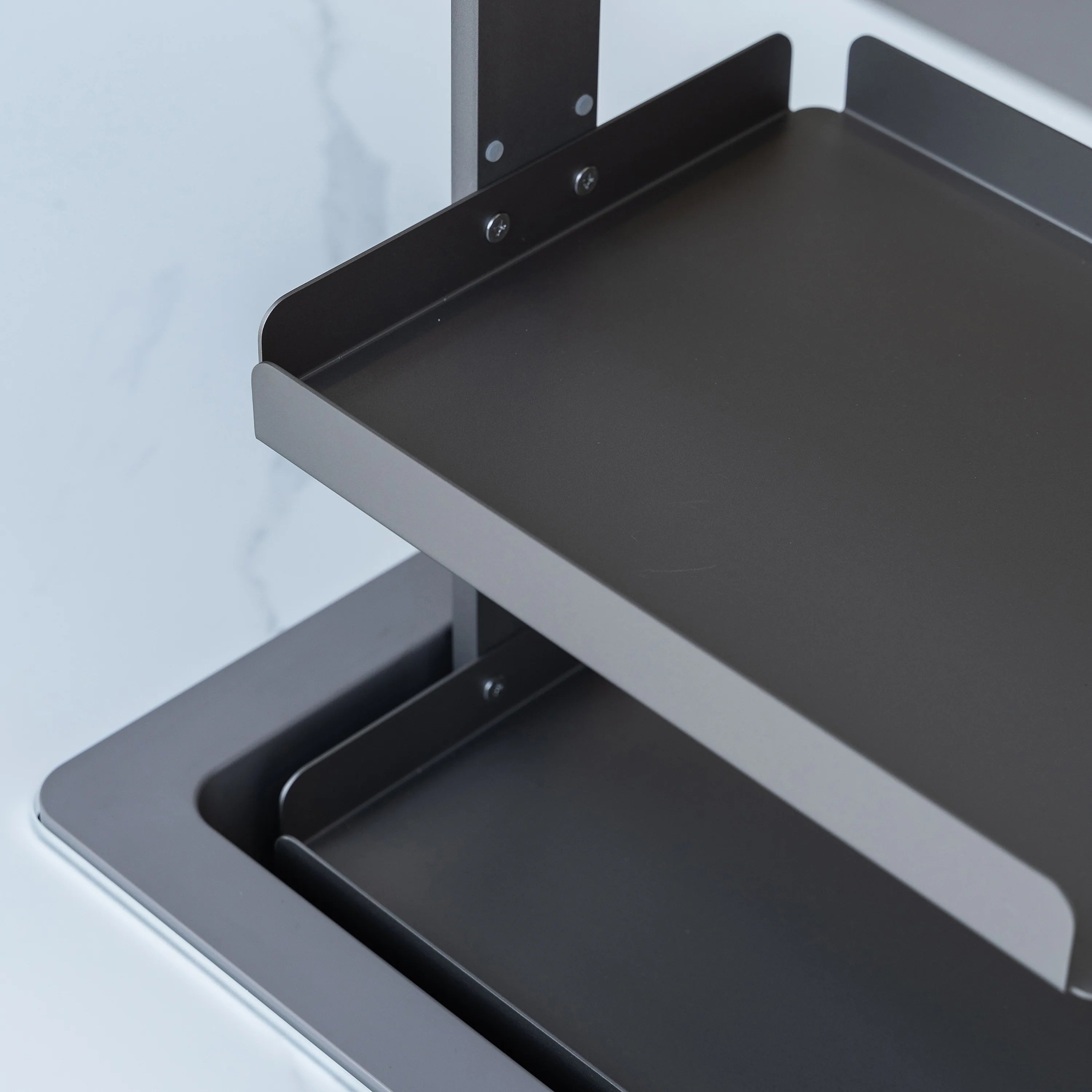 Open refrigerator compartment with dark interior shelf and side mounting brackets