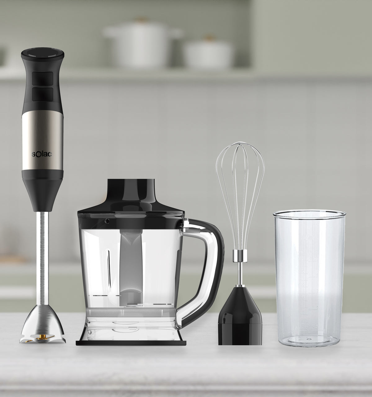Hand blender kit with blending shaft, whisk, cup, and chopper on countertop
