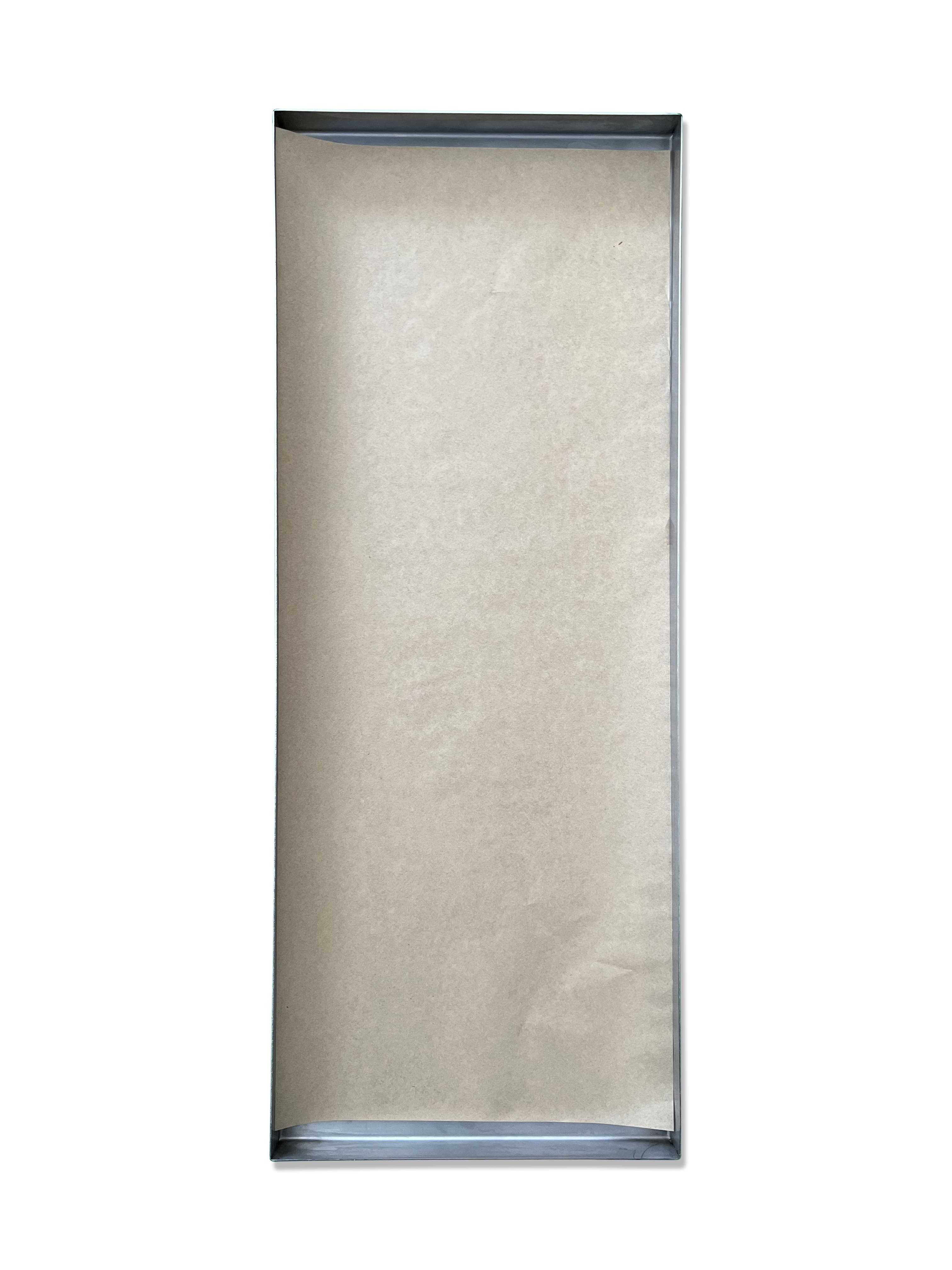Light beige parchment paper sheet lined in a metal baking tray