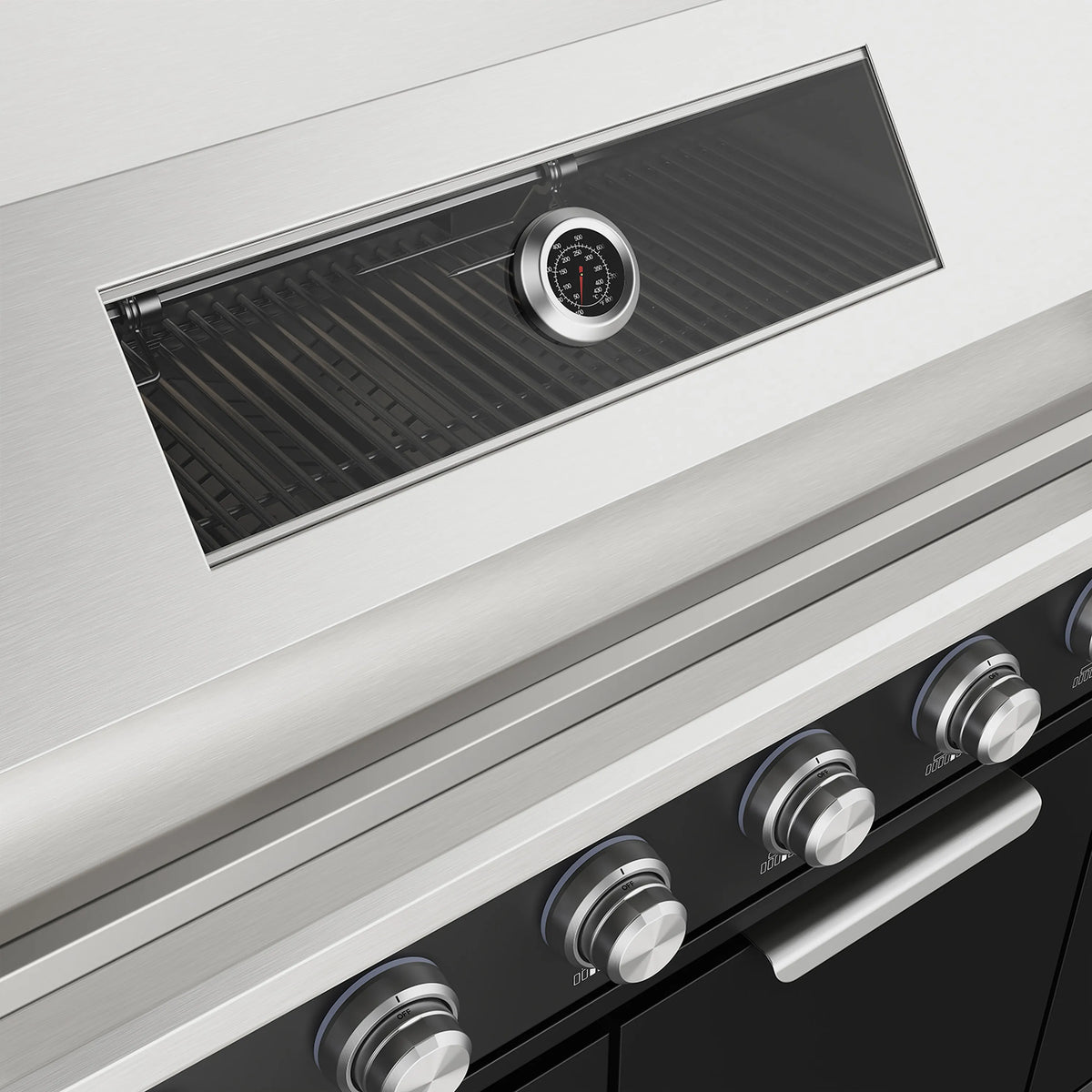 Stainless grill hood with temperature gauge and vented panel above black control knobs