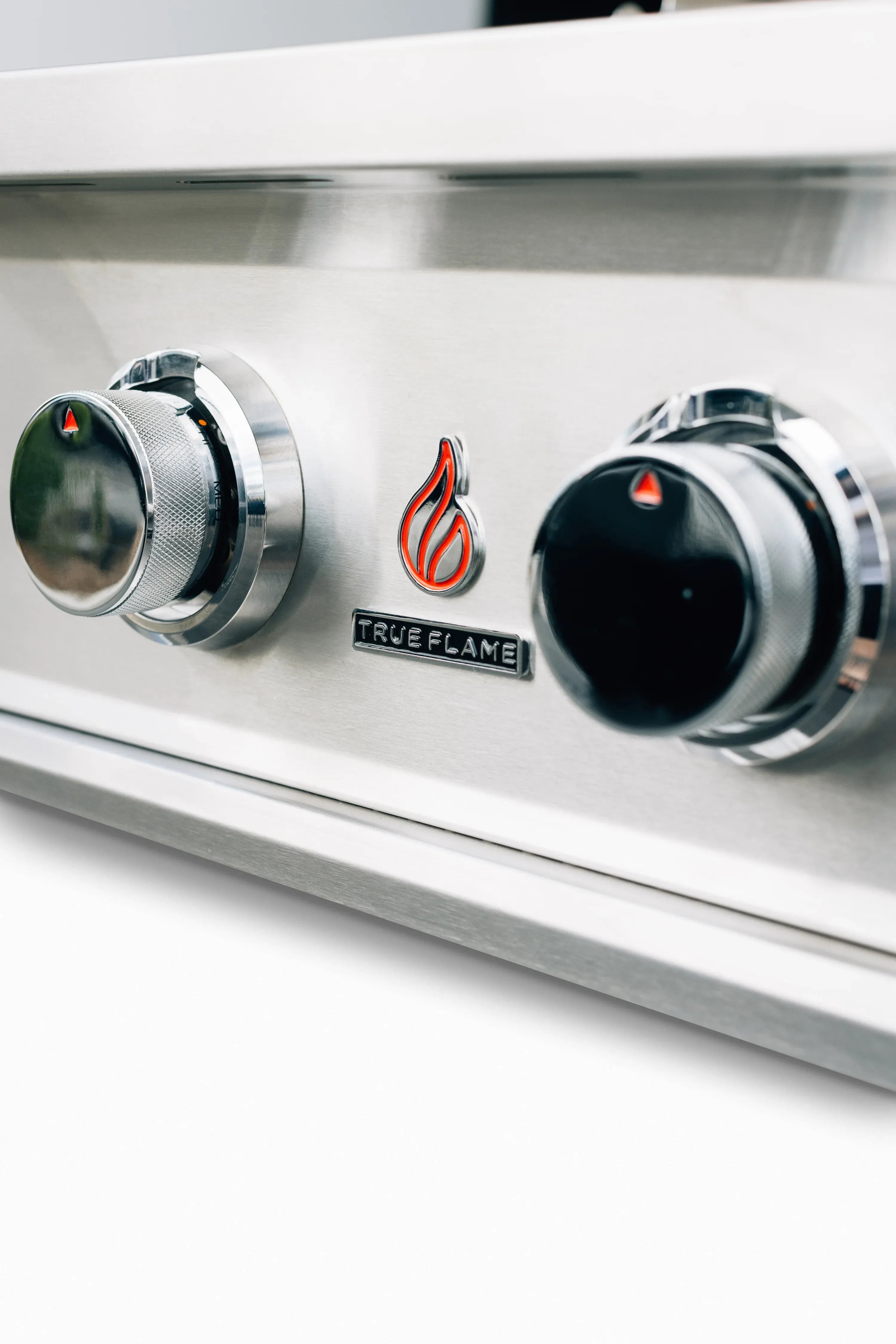 Stainless steel grill control panel with three burner knobs