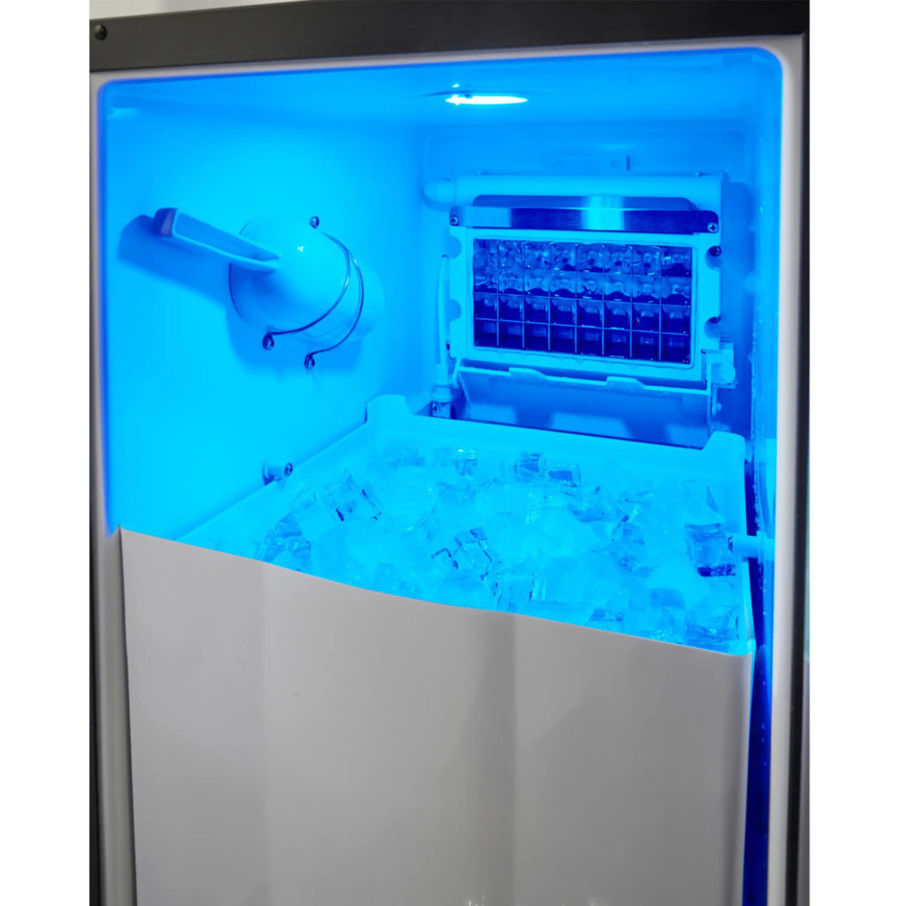 Built-in ice maker showing ice tray and bin with interior light
