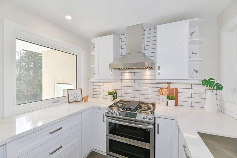 Chimney-style stainless steel wall hood above a gas range