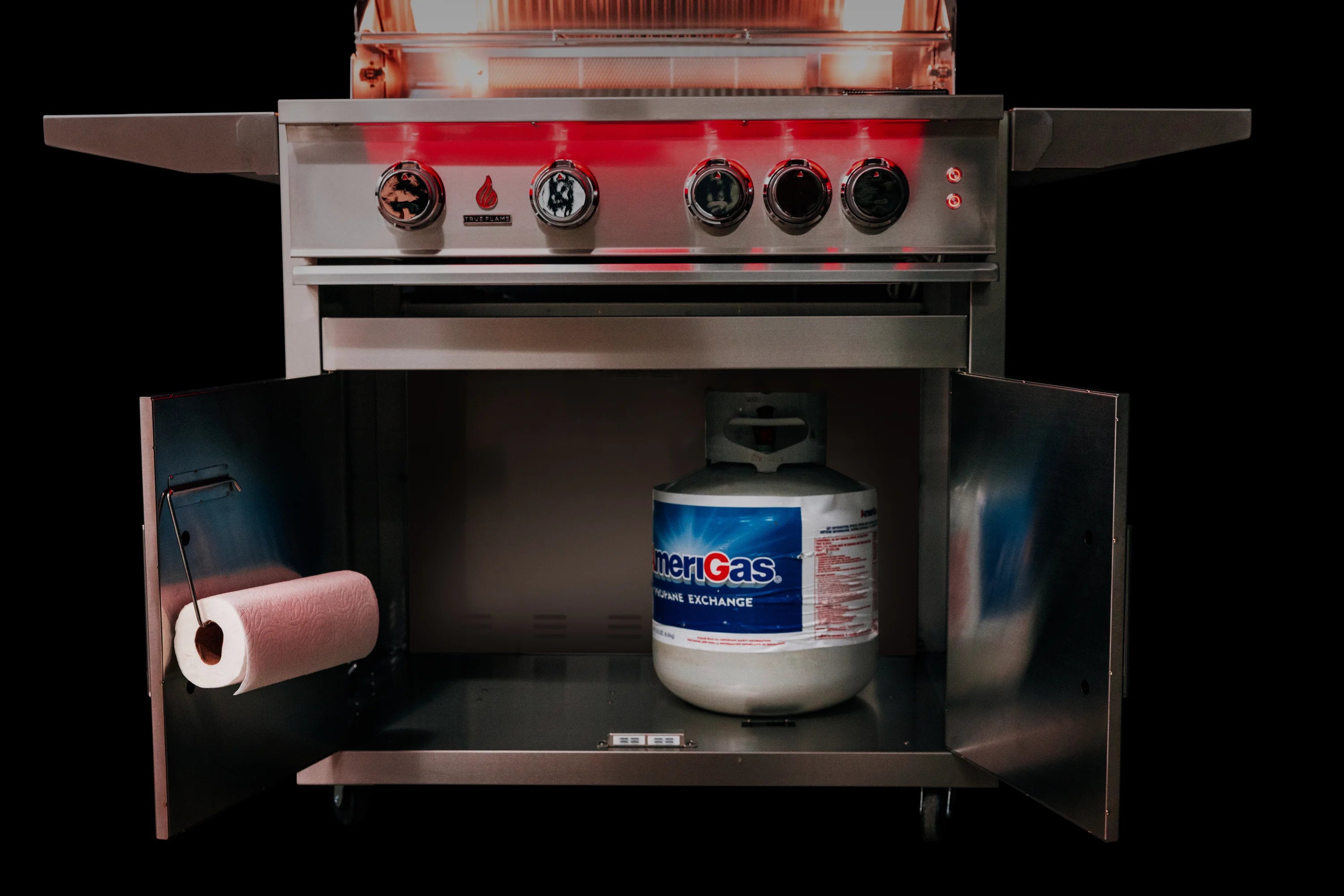 Open grill cart interior with stainless control panel and propane tank storage