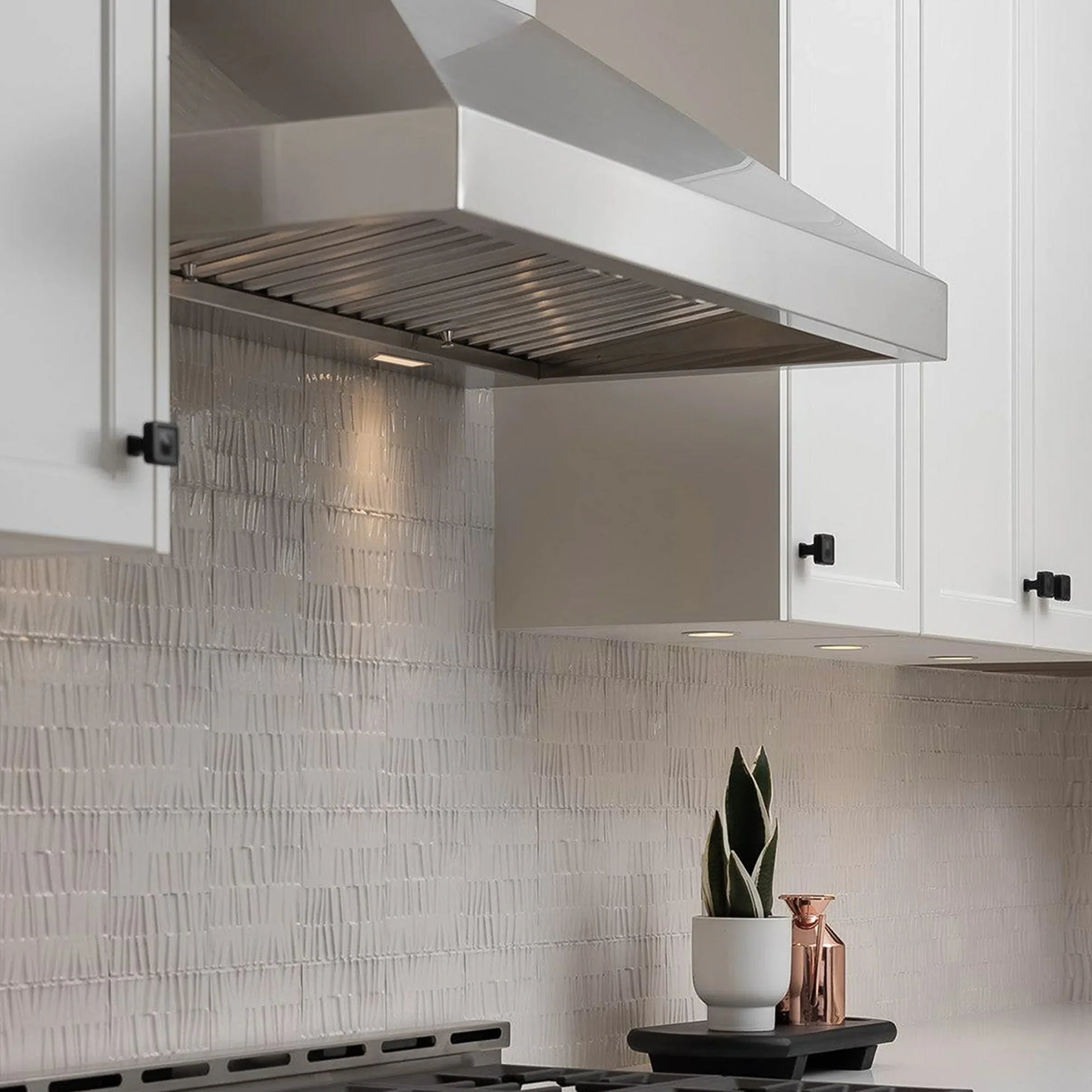 Stainless steel wall-mount range hood with curved chimney and vented fan canopy