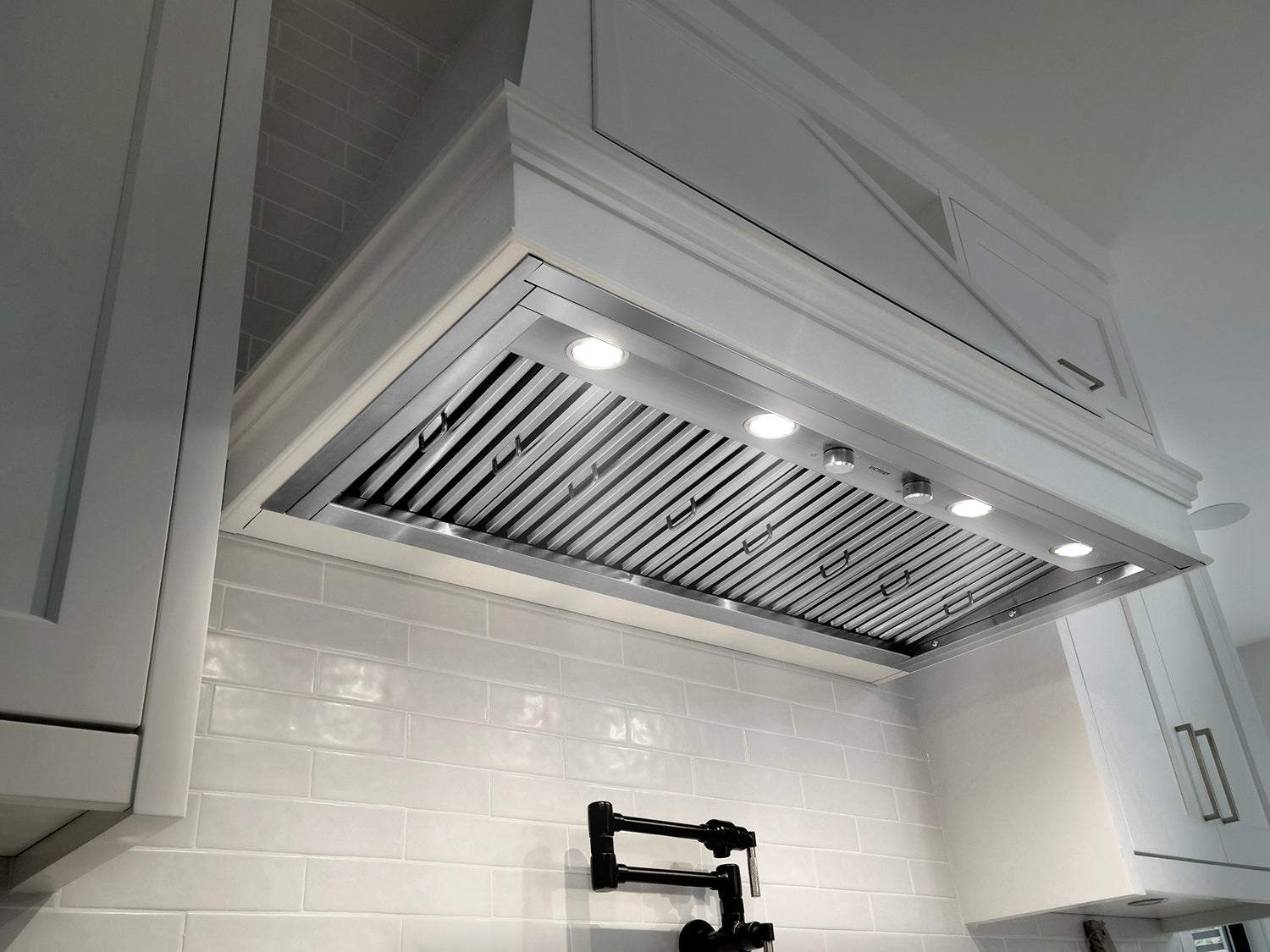 Stainless steel insert range hood underside with built-in lights and vent grille