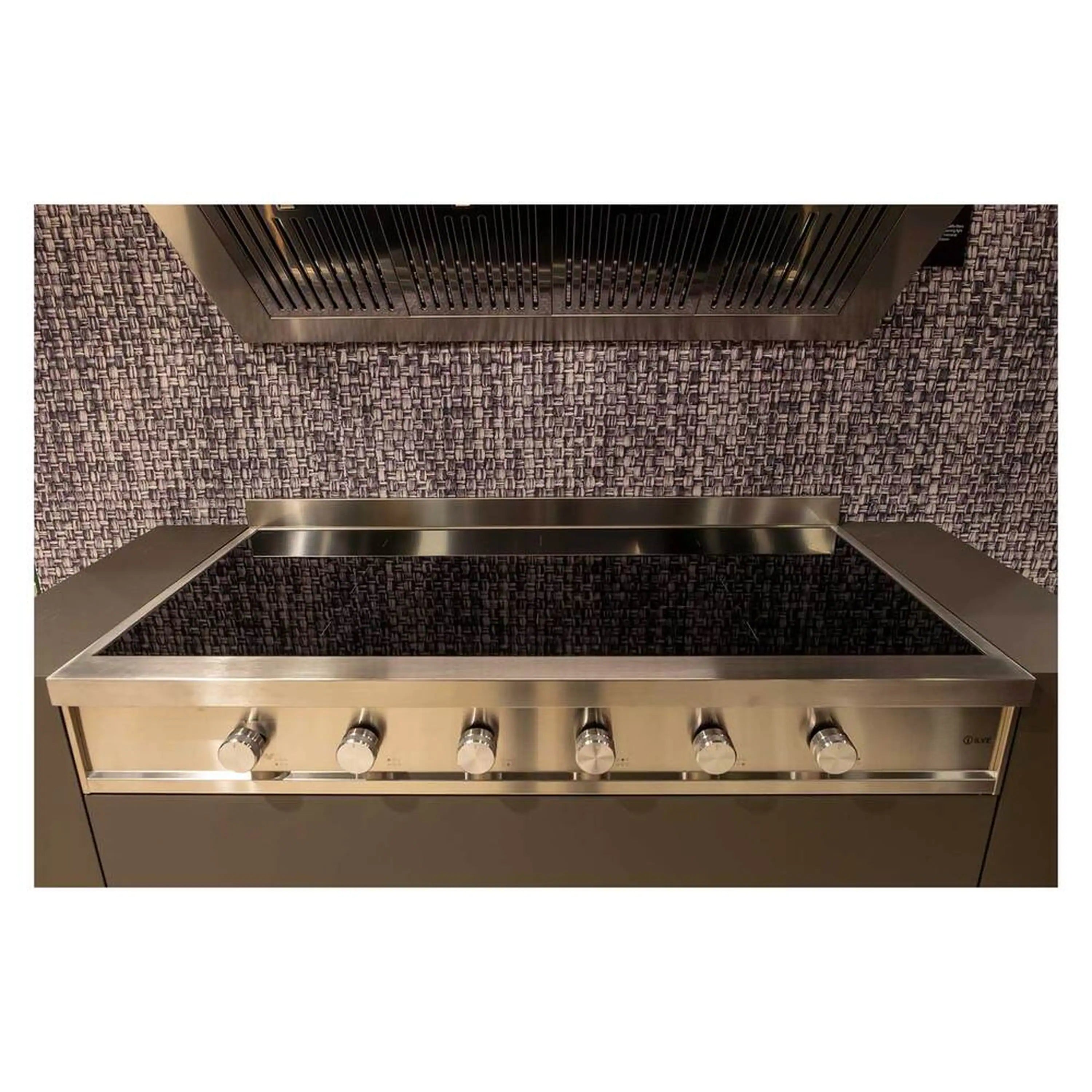 Stainless steel built-in induction cooktop with black glass surface and row of control knobs