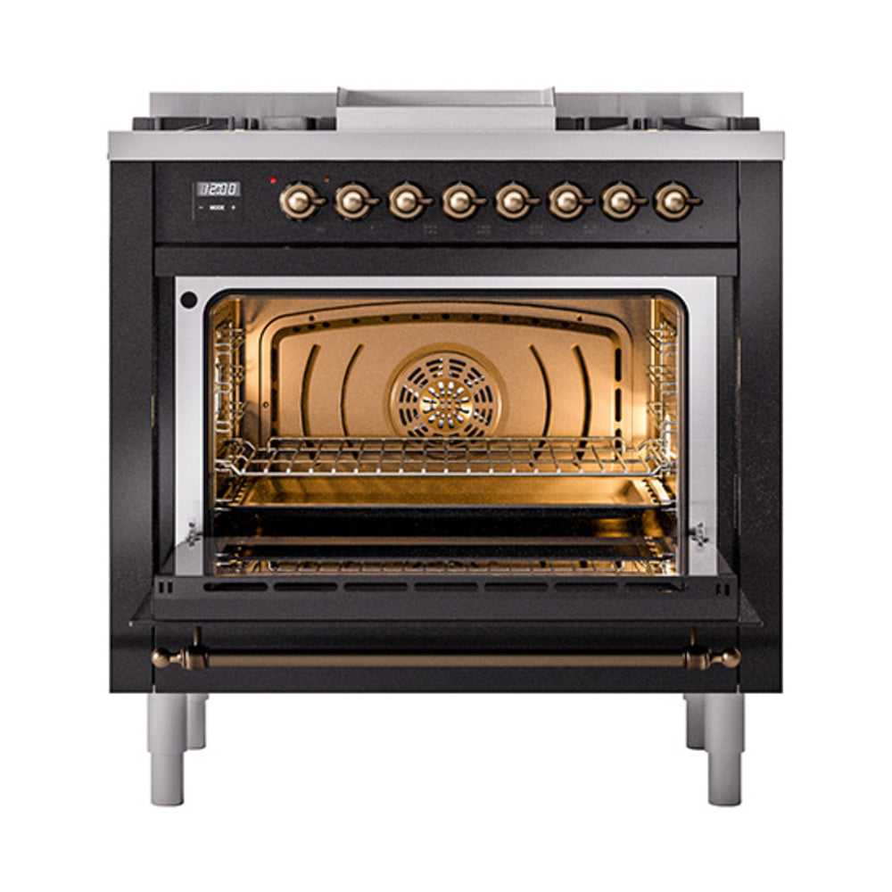 Glossy black dual fuel gas range with bronze knobs and lit oven interior