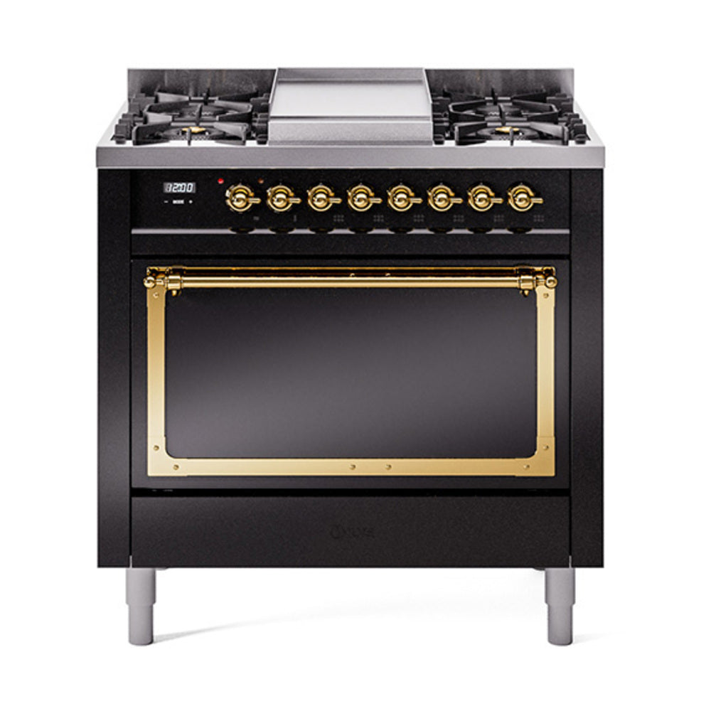 Glossy black dual-fuel gas range with brass-trim oven door window and control knobs