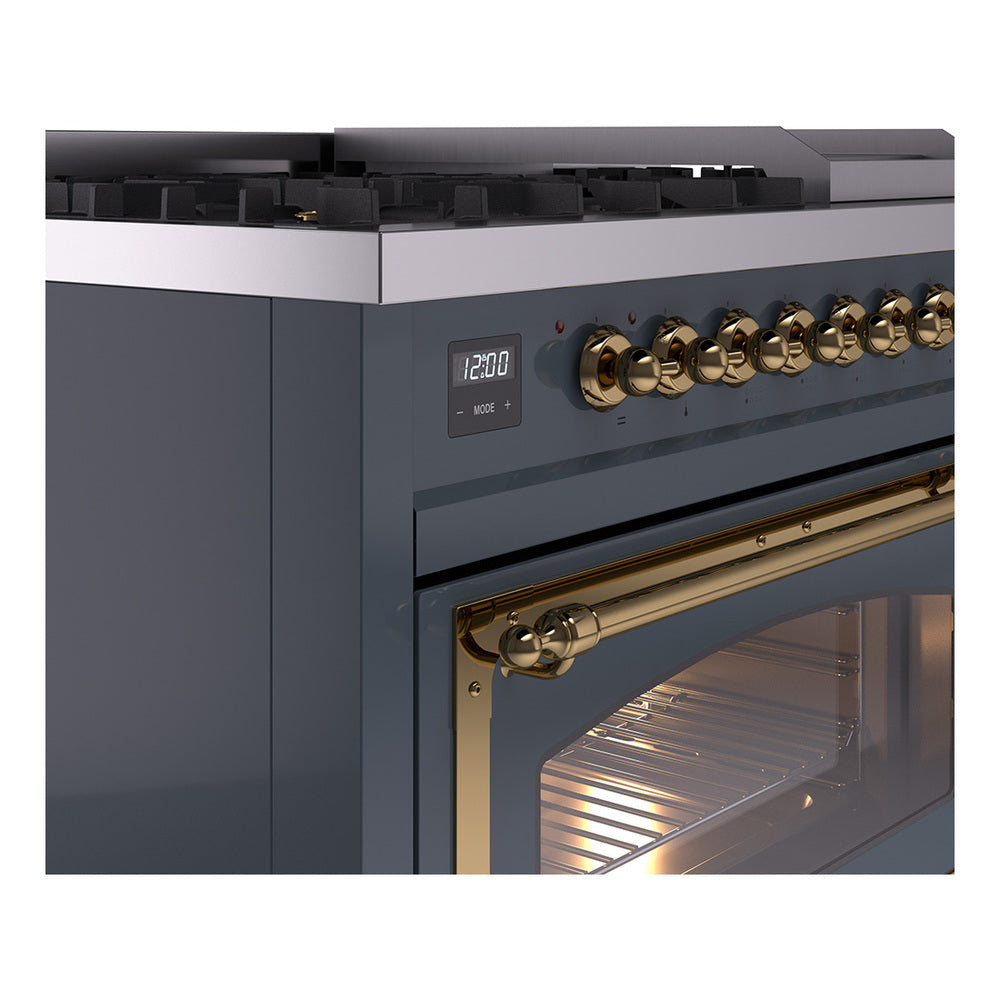 Close-up of brass control knobs and handle on blue grey freestanding dual fuel range.
