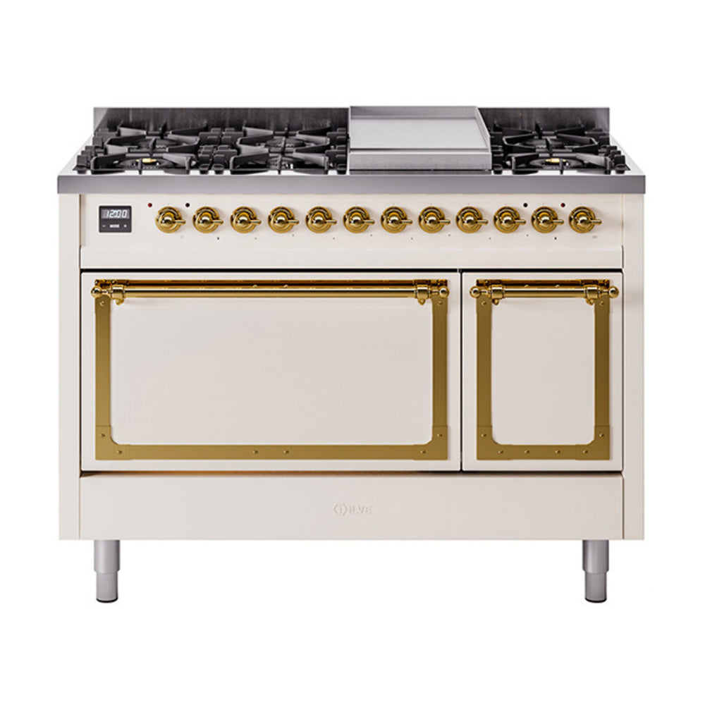 Freestanding dual fuel range with closed ovens, antique white doors, and brass trim handles.