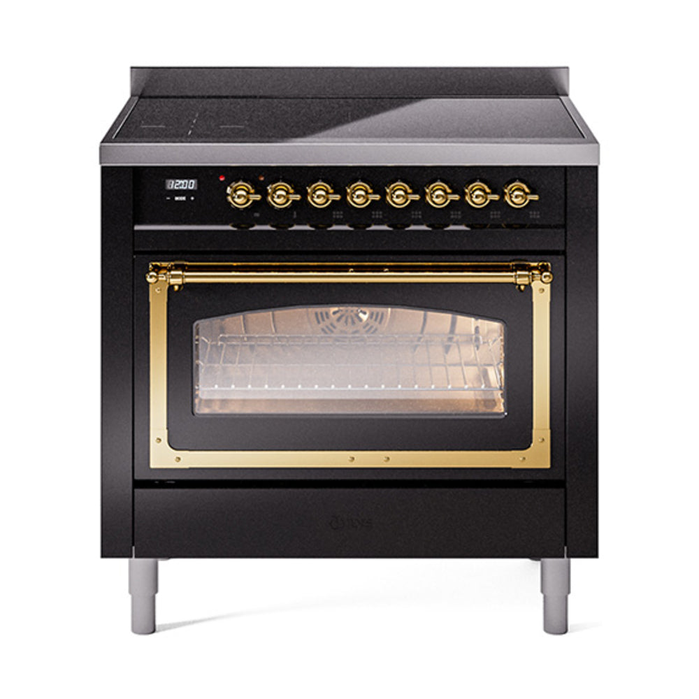Black induction range with brass control knobs and closed oven door window