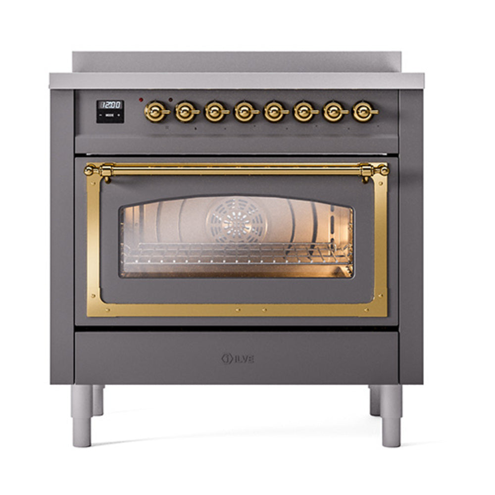 Matte graphite induction range with brass control knobs and lit oven door window
