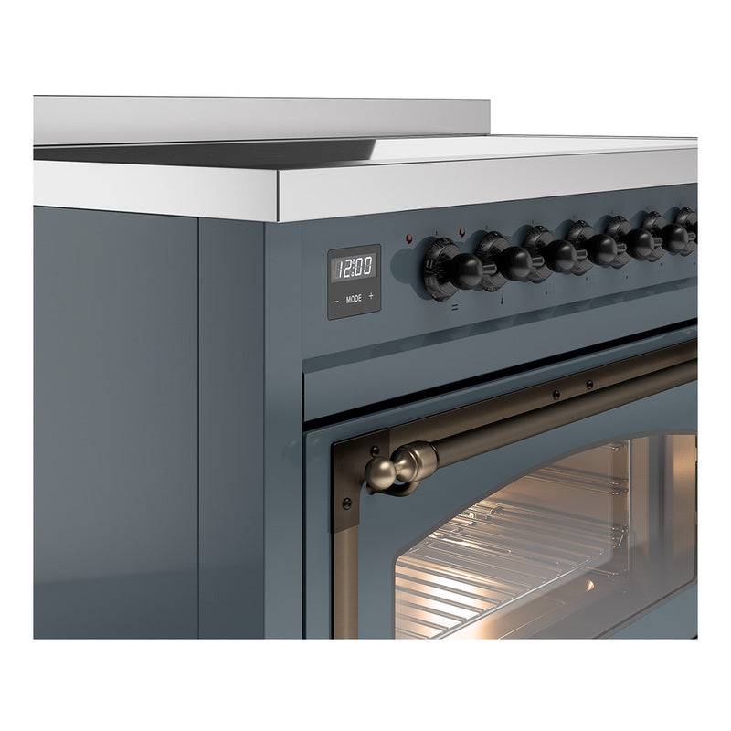 Close-up of induction range control knobs, display, and bronze oven handle