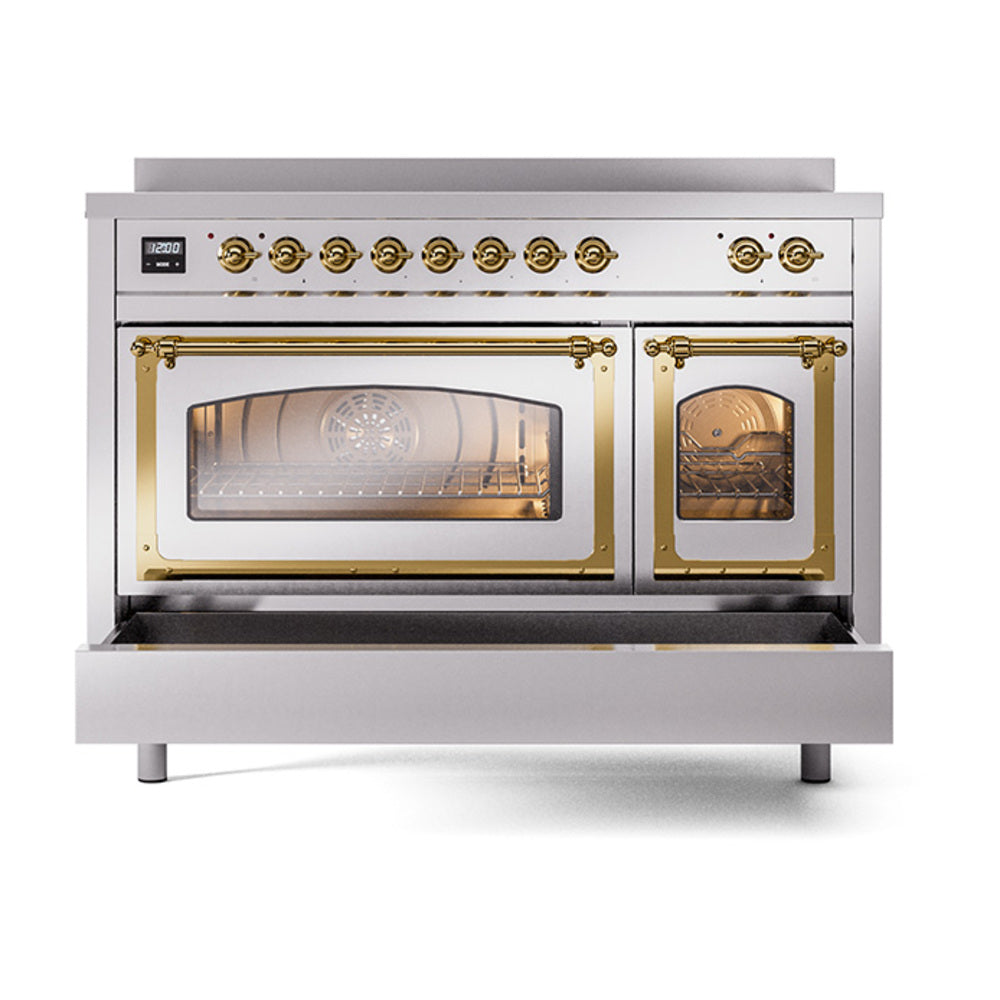 Stainless steel induction range with lit oven interiors behind brass-trim glass doors