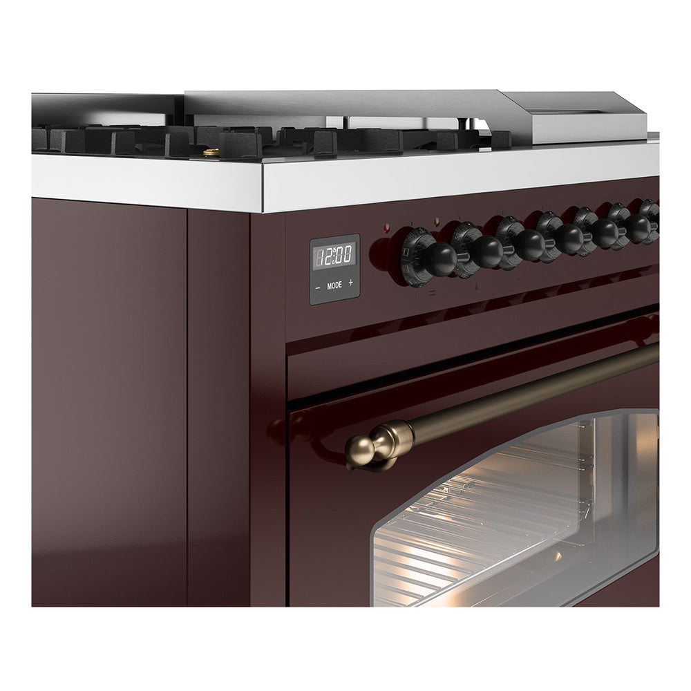 Close-up of burgundy gas range front with control knobs, bronze handle, and oven window