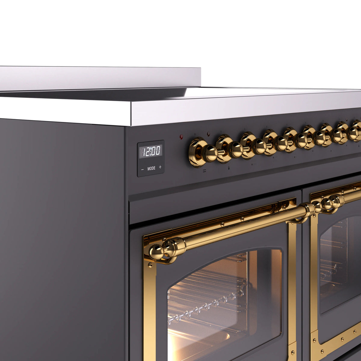 Brass control knobs and matte graphite oven handle on induction range, close-up view
