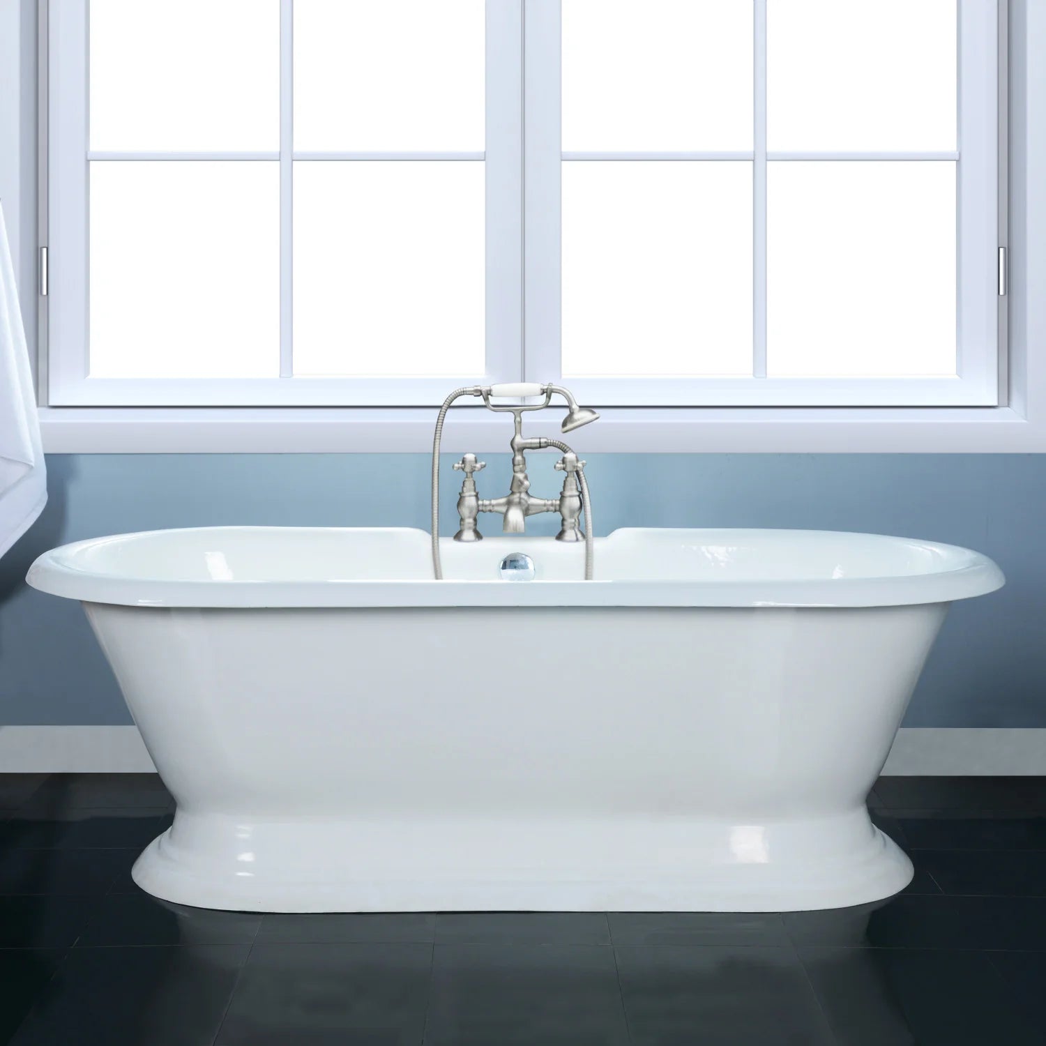 White oval pedestal bathtub with deck-mounted faucets and glossy enamel finish