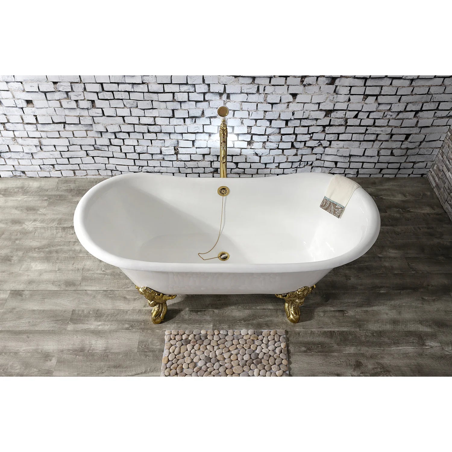 White oval freestanding clawfoot tub with polished brass feet and back overflow opening