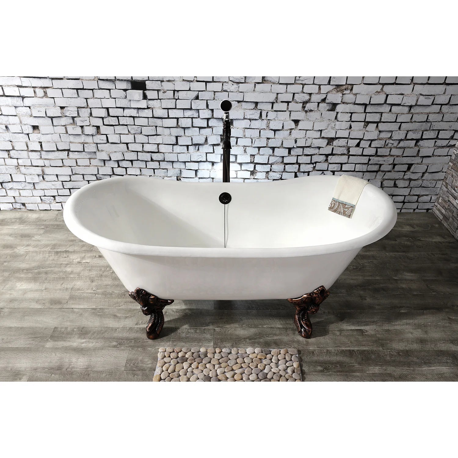 White oval cast iron clawfoot tub with dark bronze feet and center drain/overflow