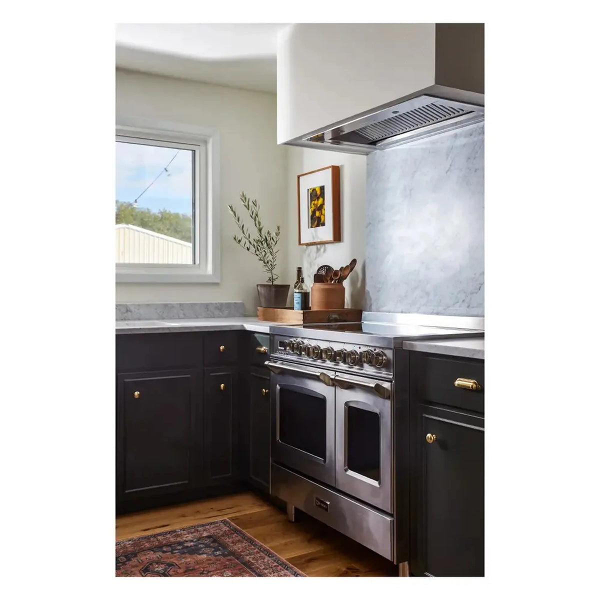 Stainless electric range with double ovens and under-cabinet hood, angled view