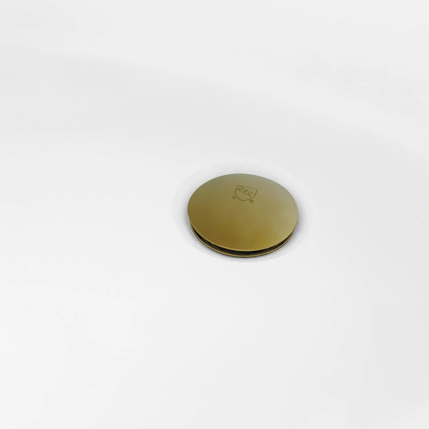 Brushed brass drain cover on glossy white oval acrylic tub