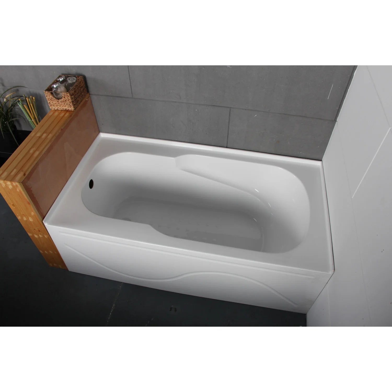 Installed glossy white acrylic alcove tub with visible left-side drain opening