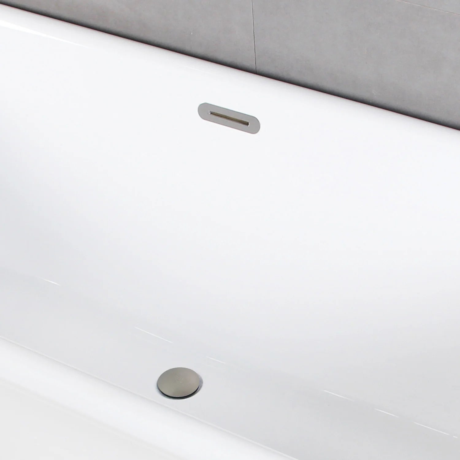 White oval acrylic tub side view with brushed nickel drain and overflow opening