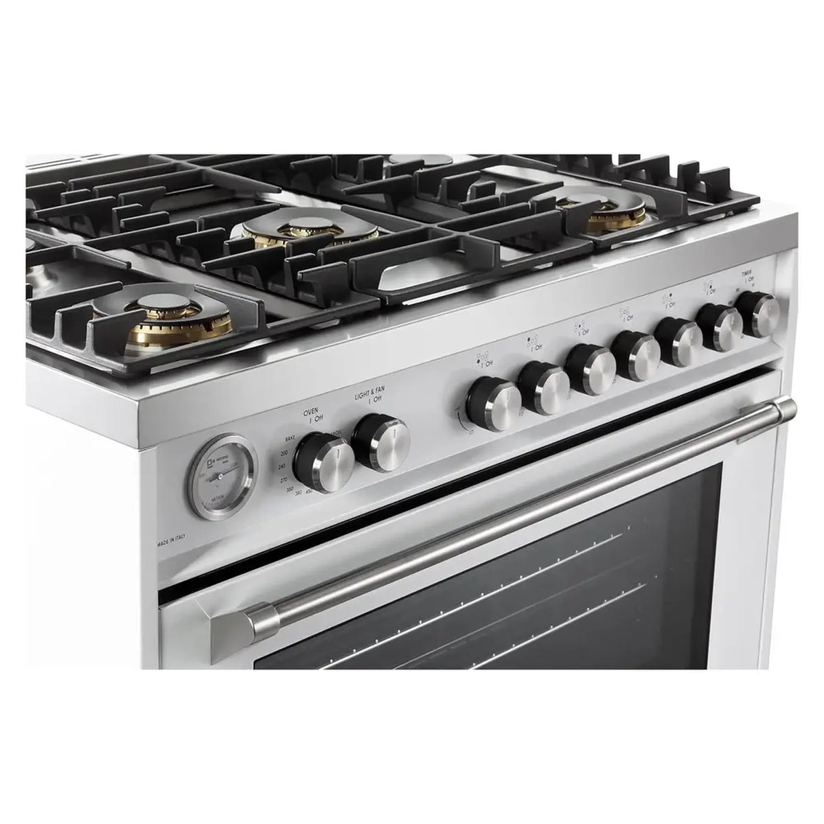 Stainless and white gas range front detail with burner knobs and oven window