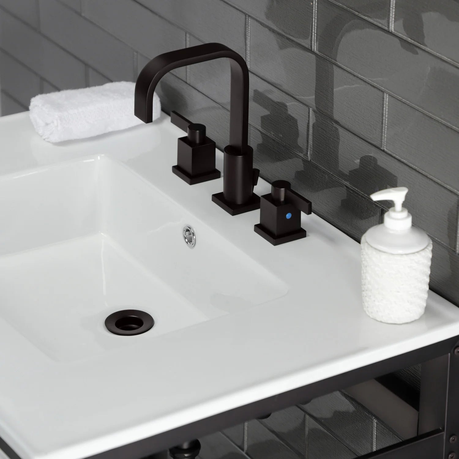 White ceramic console sink with dark bronze widespread faucet and soap dispenser