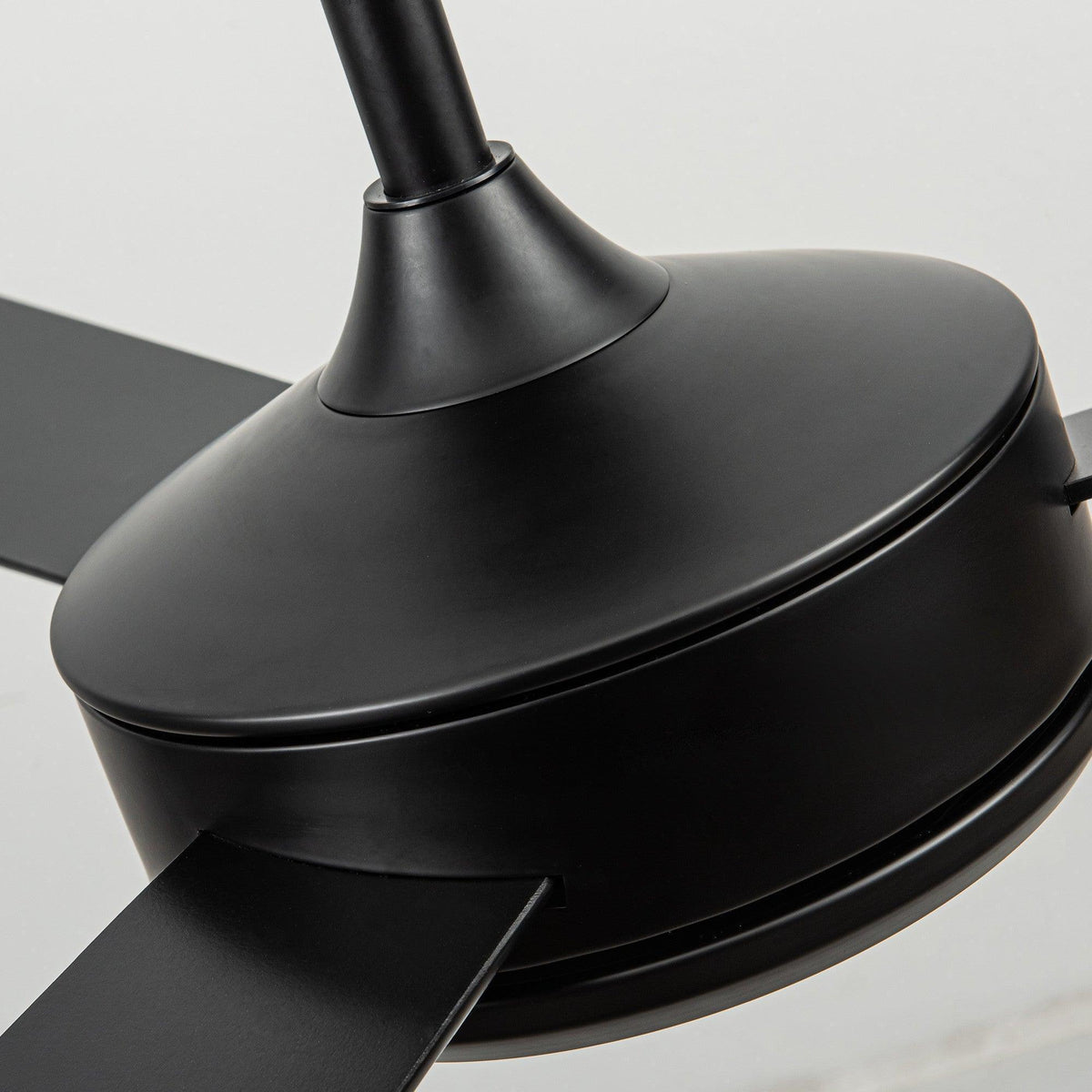 Black ceiling fan blade and curved motor housing with glossy finish.