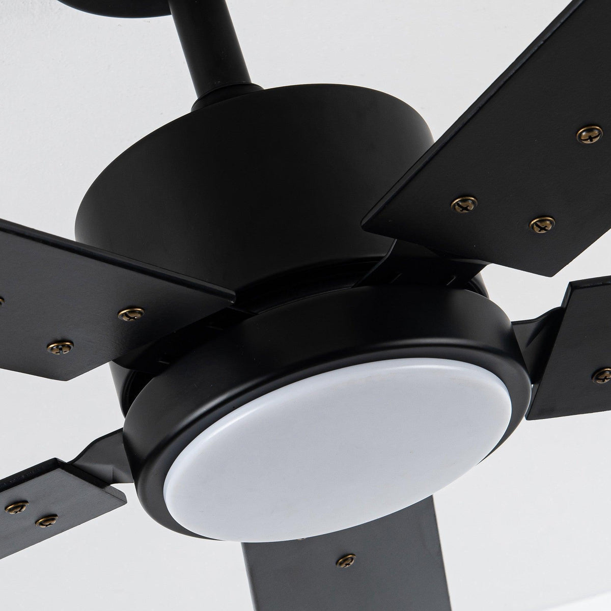 Close-up of black ceiling fan motor housing with frosted circular LED light