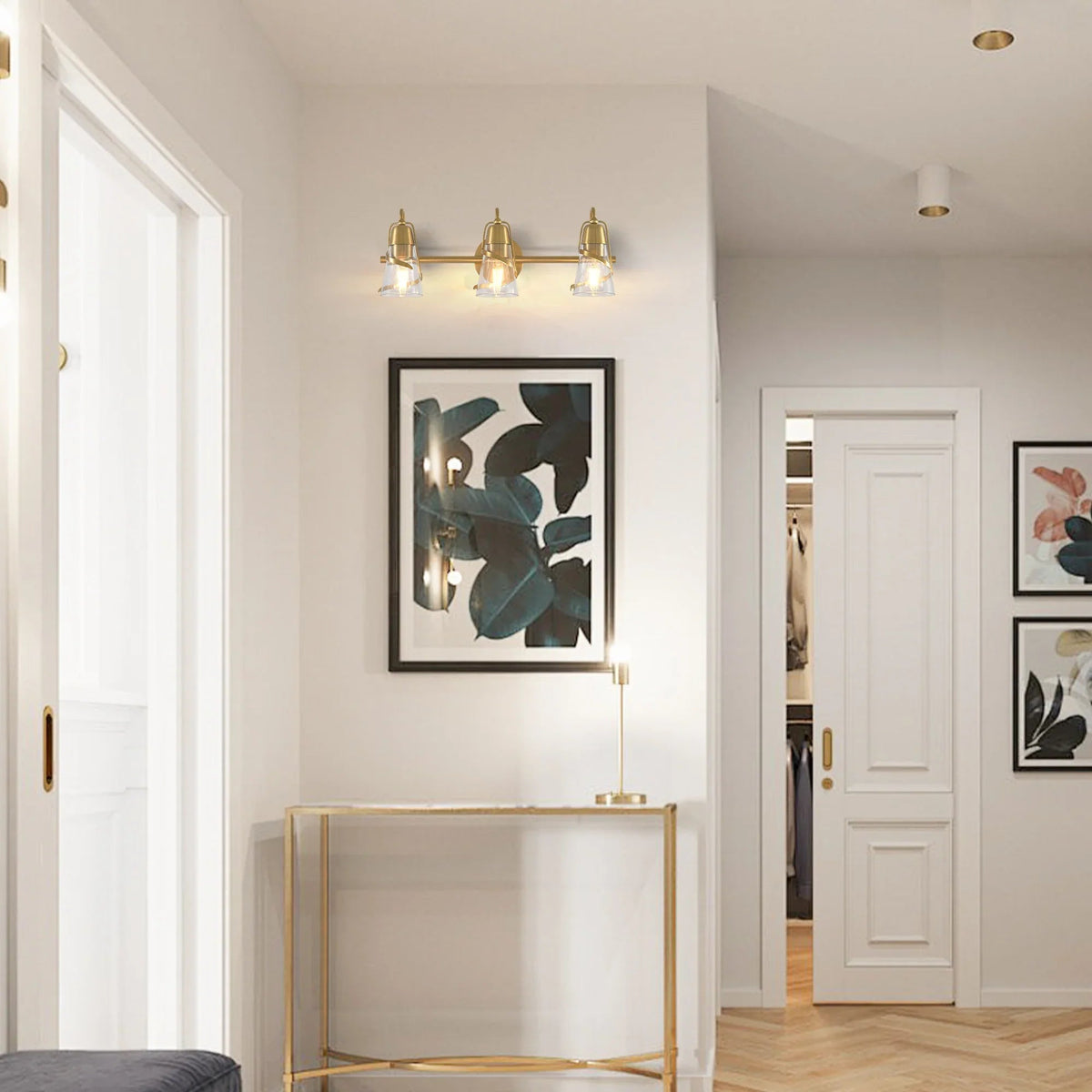 Golden 3-light vanity light with clear glass shades mounted above a console