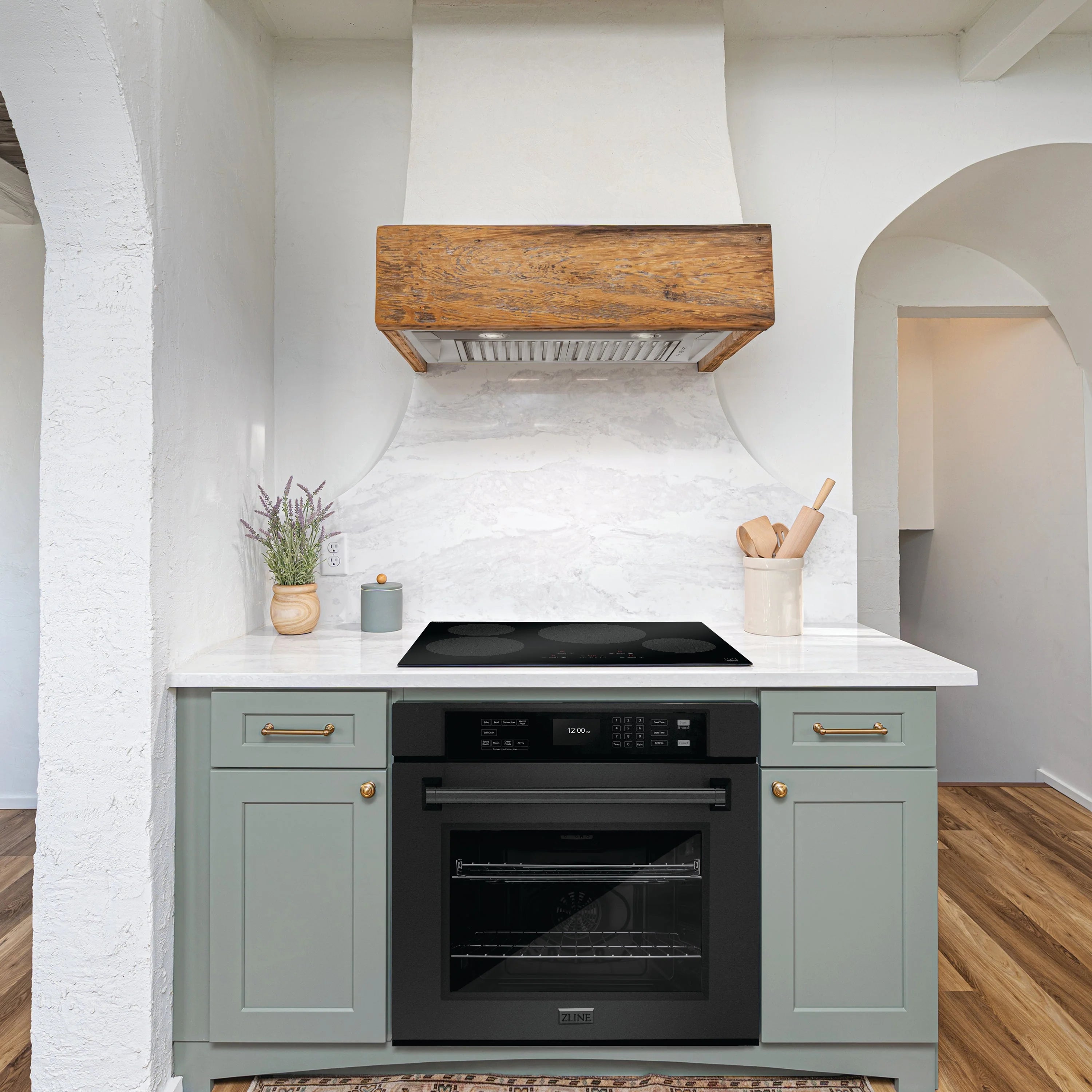 Black electric range with oven and cooktop in gray cabinetry, hood above