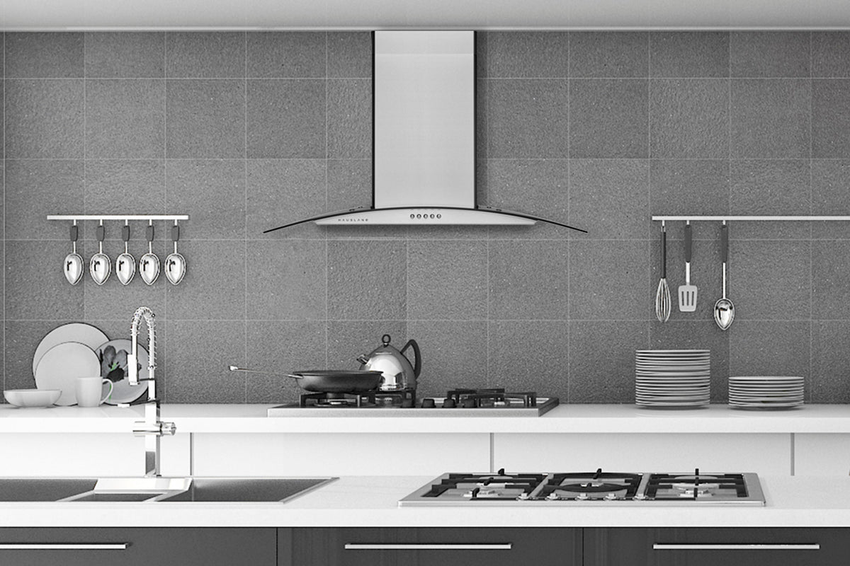 Stainless wall-mount range hood over cooktop with chimney housing and vent