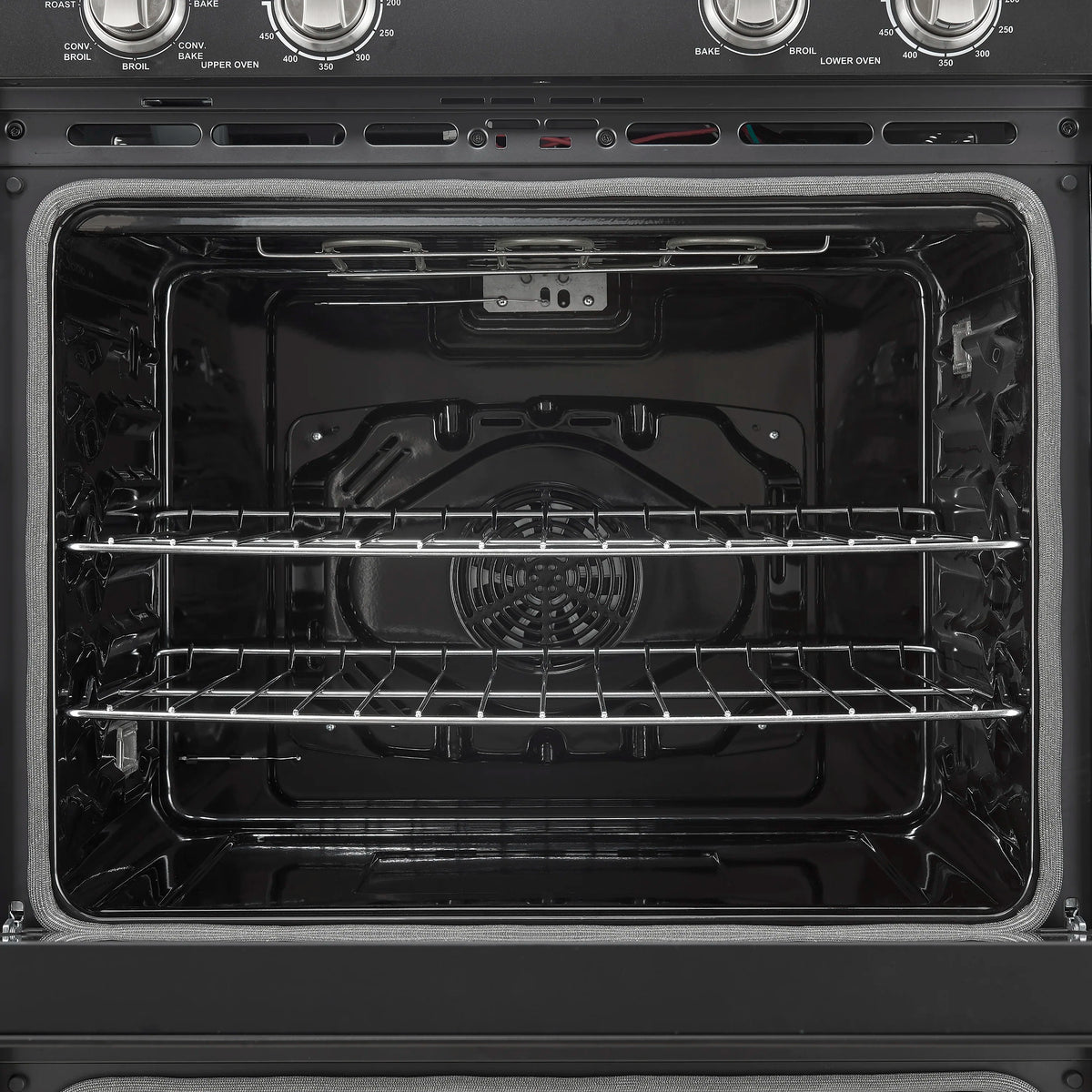 Black oven cavity with wire rack shelves and circular convection fan inside.